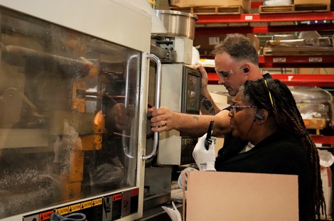 The Technology House team members working with 3D printing machine