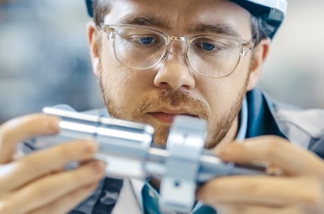 Manufacturer examining a metal part